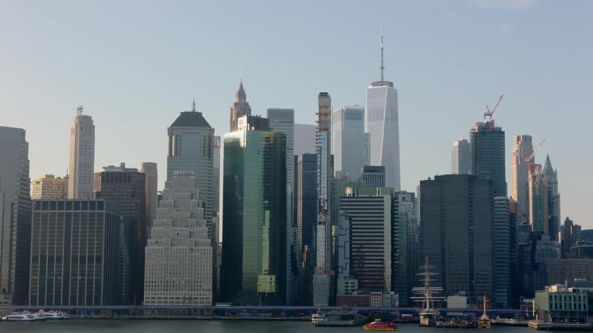 Skyscrapers looming over a bridge near a waterfront in a metropolis