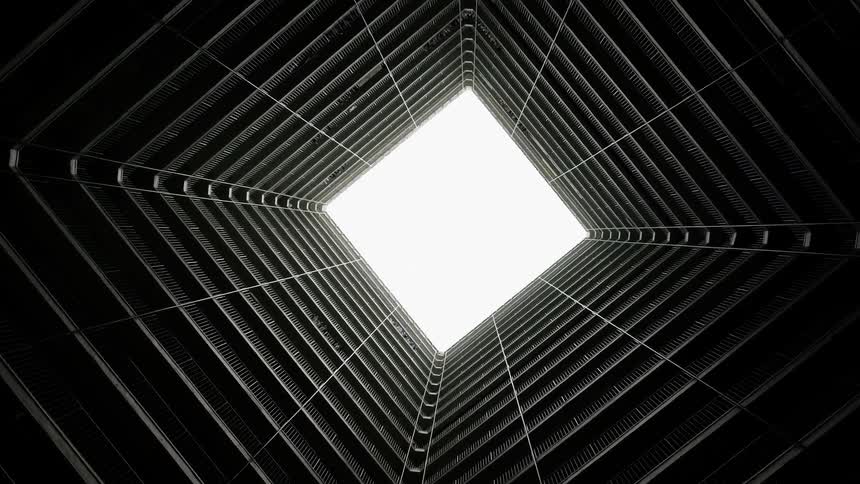 A building with a square lobby with the sky above