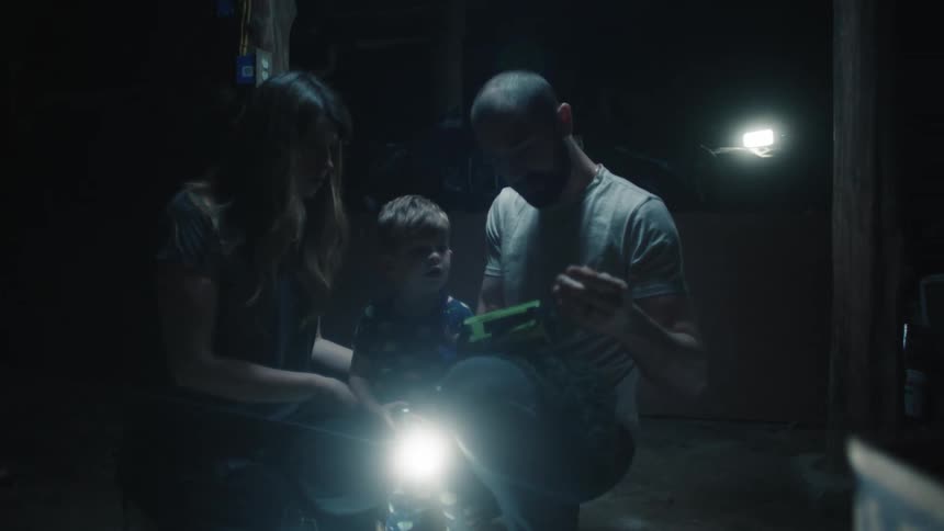 A man woman and child are standing together in the dark
