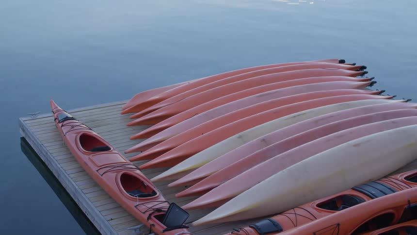 Splashing in water near kayaks stacked on wooden platform surrounded by water