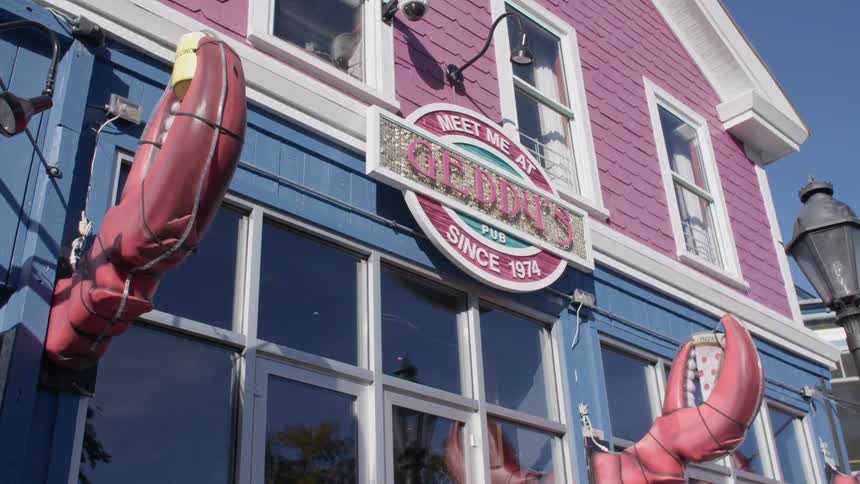 Two crab claws adorn the front of geddys pub in bar harbor on a sunny day