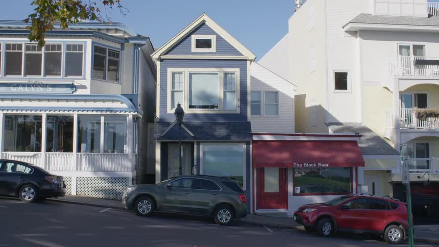 The cars are parked in front of the buildings