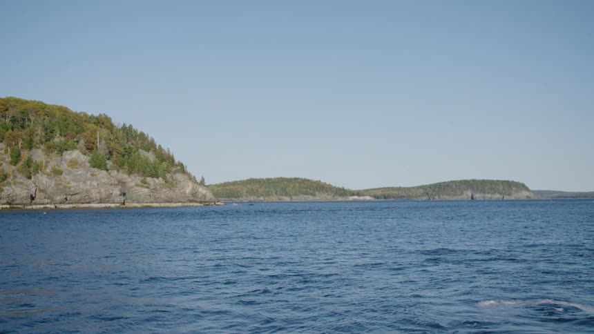 Hills on a coast in front of calm sea waters at day