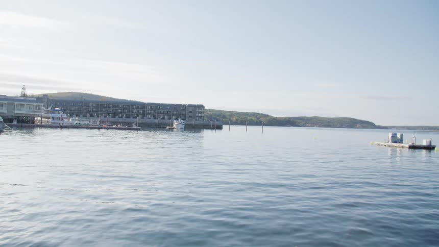 A raft and a boat float on a large body of water off the coast