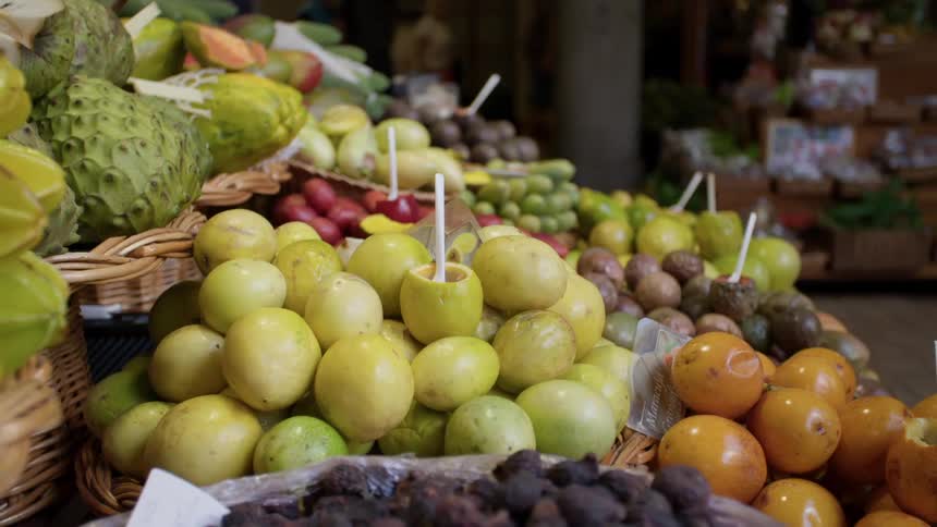 Several baskets of fruit are displayed on a stand