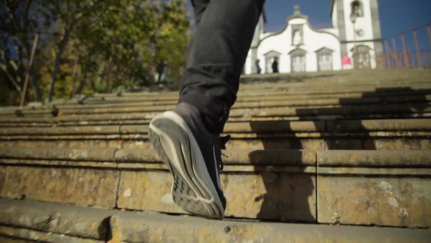 Tennis shoes walking up stairs towards a white church