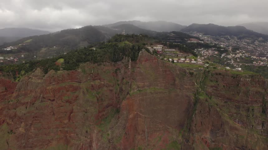 A small village of homes on hillside and cliffs on a cloudy foggy day