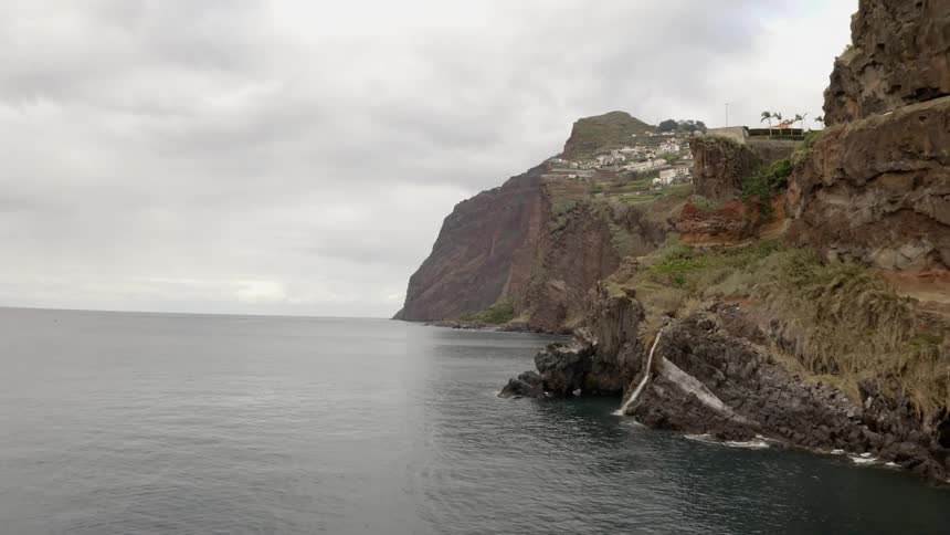 A neighborhood sits above a cliff over the water