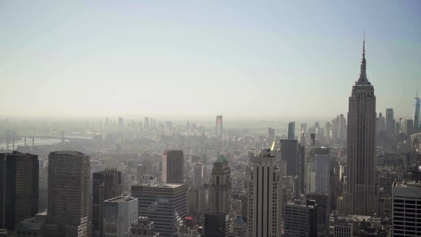 The empire state building and surrounding buildings in new york city on hazy day