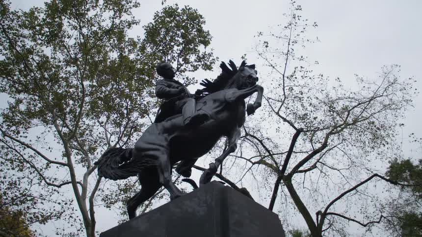 Statue of a man over a horse in a public park