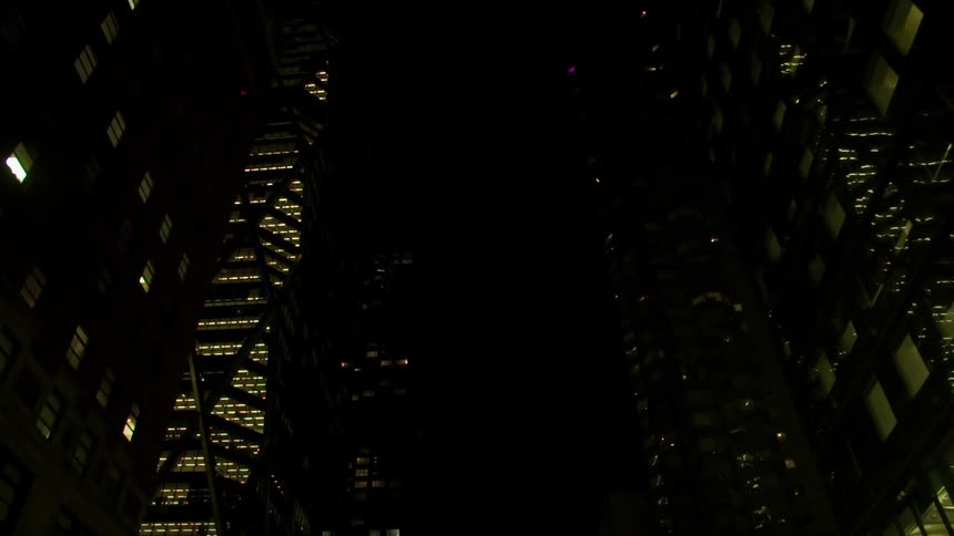 Skyscrapers are illuminated against a night sky