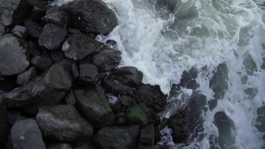 Foamy waves crash on a rocky shore