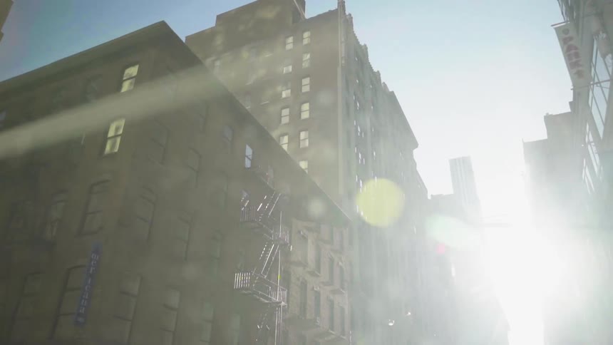 Blinding sunlight shining between rows of skyscrapers in a metropolis