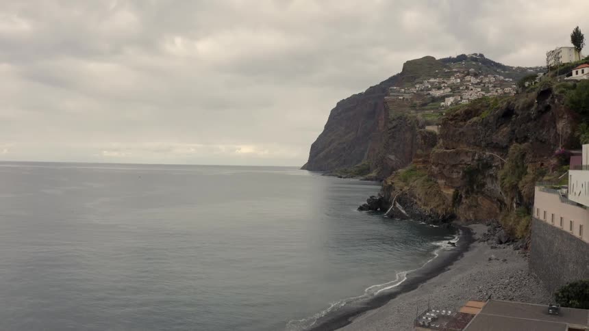A rocky promontory on the ocean bordering a small beard with a small restaurant