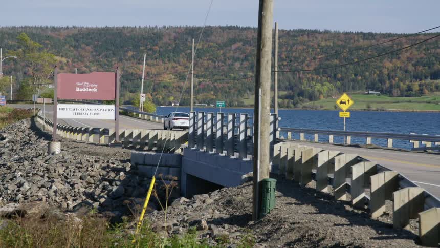 A car drives across a bridge over a lake