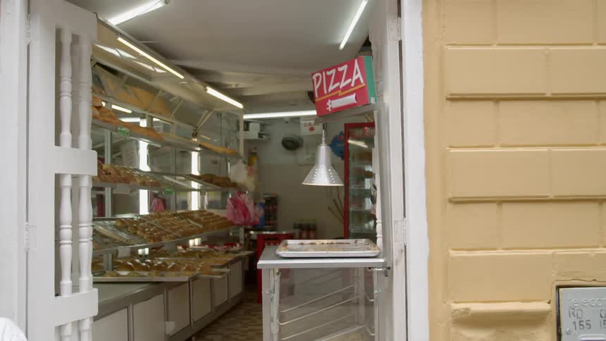 Trays of pizza sit on shelves in a restaurant
