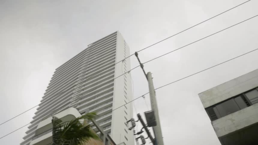 A skyscraper rises high into the sky over an urban area
