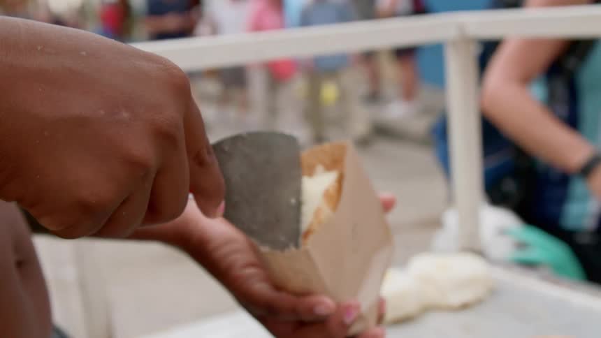 A black man prepares biscuits for customers at an outdoor event