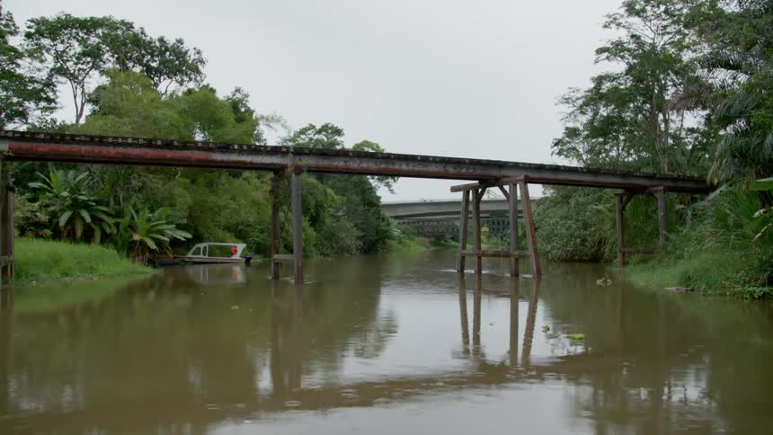 rusty bridge spanning across a muddy river