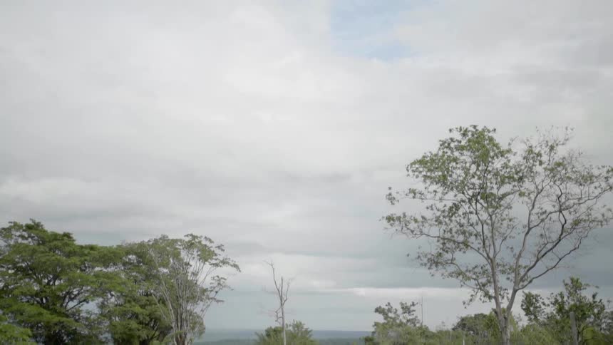 View of a rural area and a dirt road on a cloudy day