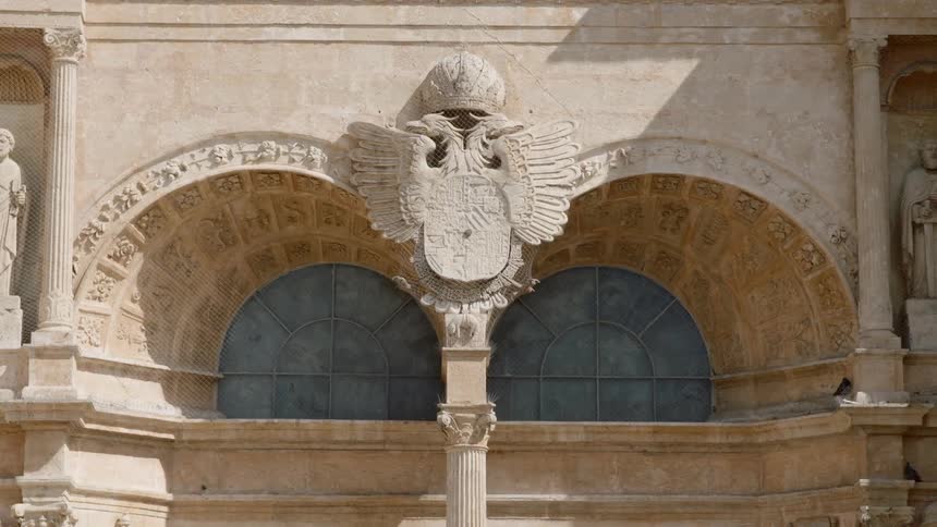 A crest decorates the outside of an old building