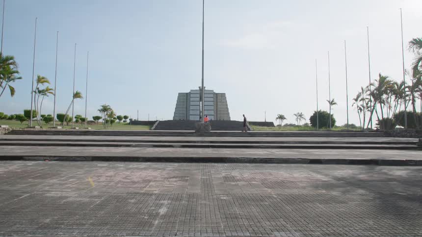 A person walks across the grounds of a monument