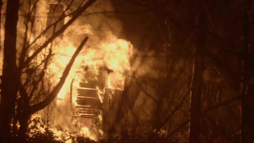 A house is on fire at night