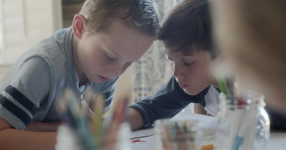 Children sitting at the table write down on a piece of paper at home