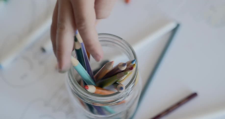 A person is grabbing pencils from a jar