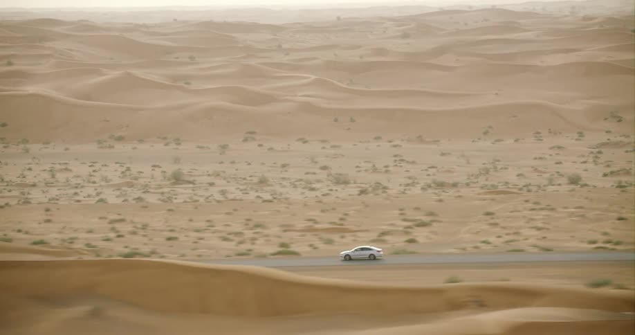 Aerial shot of a car driving in a desert