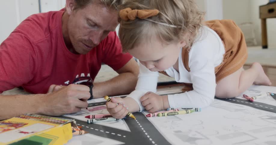 A father colors with his daughter