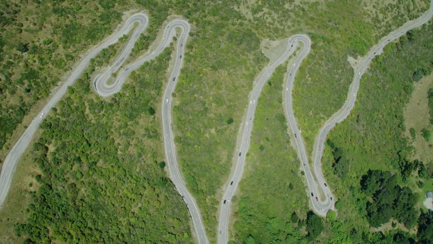 A zigzagging road with vehicles on it