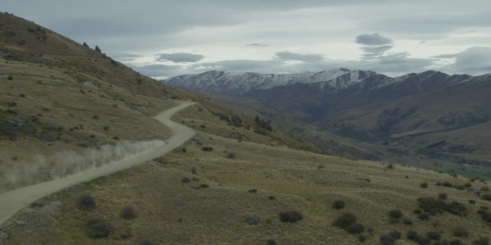 A car speeds along a dirt road