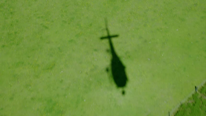 A helicopter is flying above a forest area