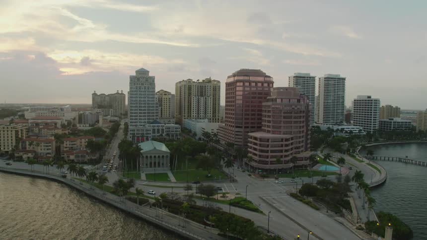 A city sits on the banks of a body of water in a tropical clime