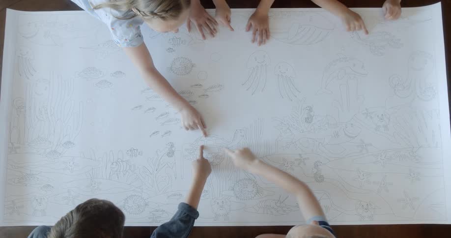 A group of children looking and pointing at a drawing