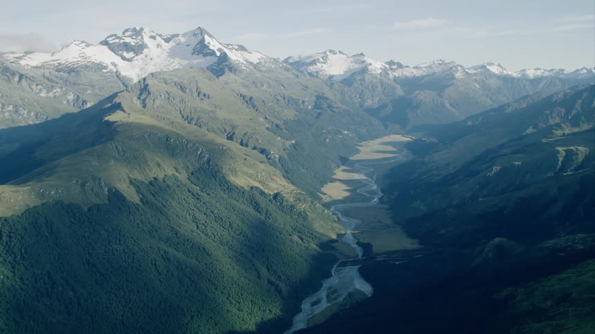 A river runs through a deep valley in between a mountain range