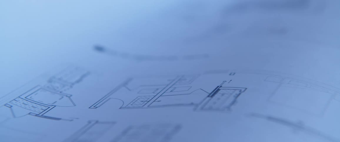 A person lifts a page exposing a sketch of plans for a building