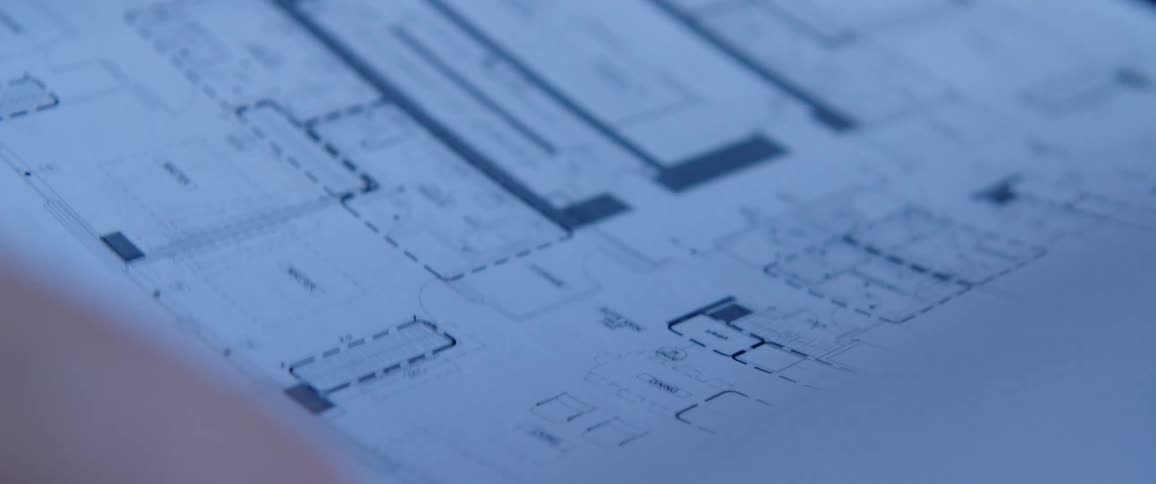 Person checking multiple pages of blueprints