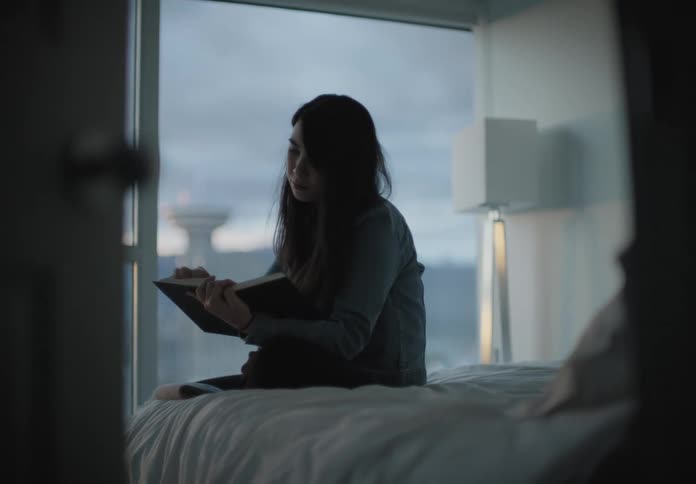 The woman reads on the bed