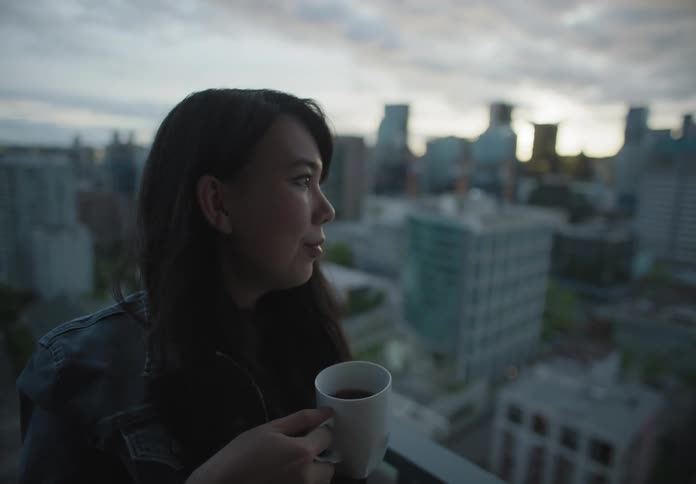 The woman drinks out of a mug