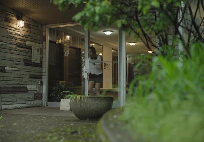 Man delivering groceries on a paper bag at doorstep for girl to pick up