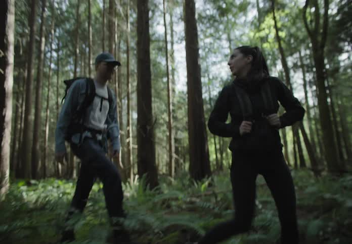 Two people hike through the woods