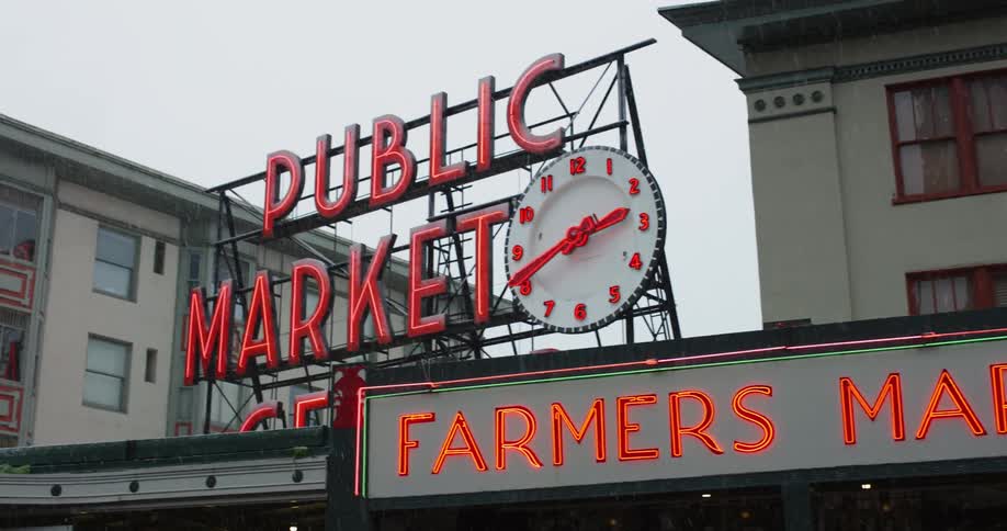A van drives by a farmers market in a city