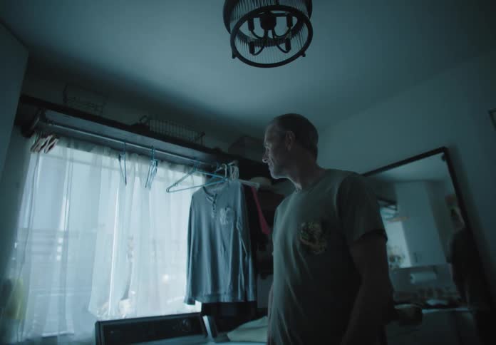 A man stands in a room looking lost and confused