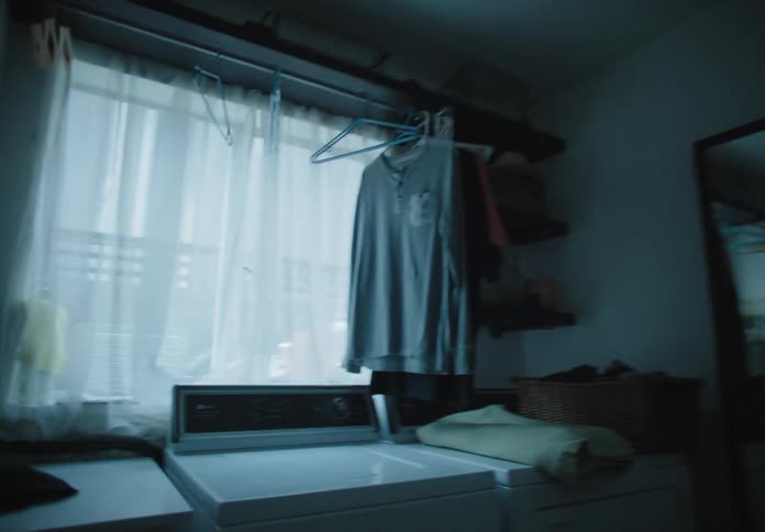 A laundry room with a mirror with lights shining off the wall