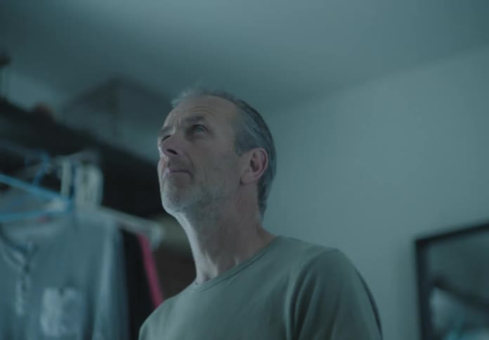 Man looks around in a dim lit room