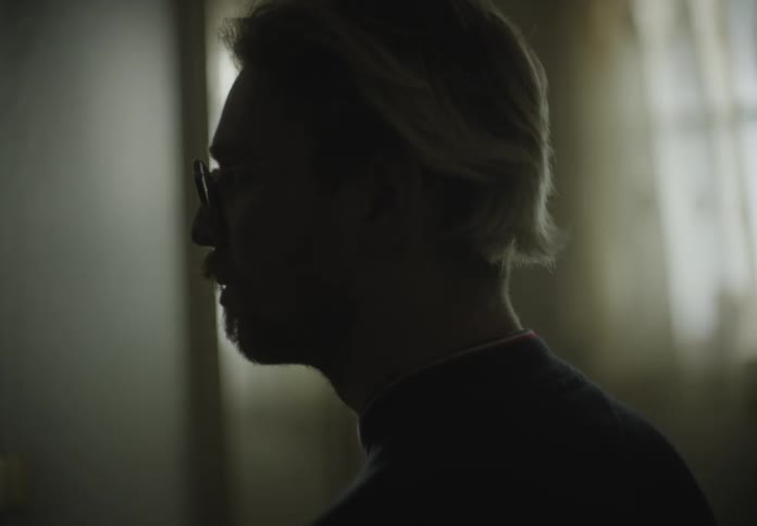 Close up of man face standing on a dimly lit room