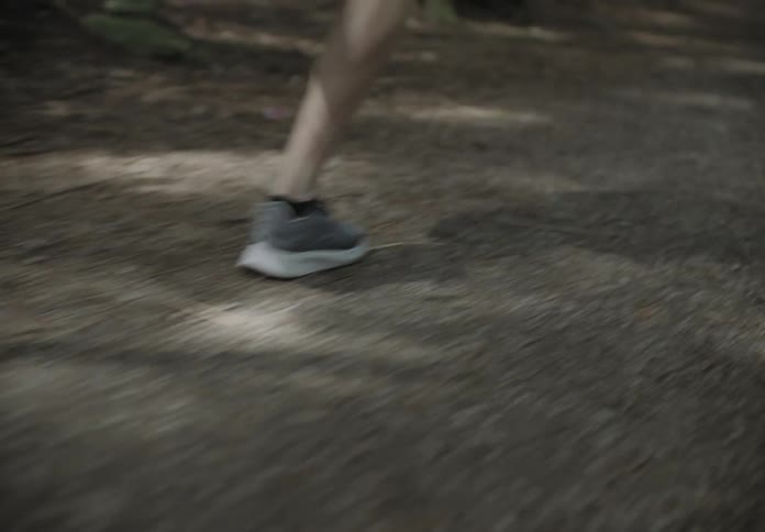 A man runs on a path in a forest