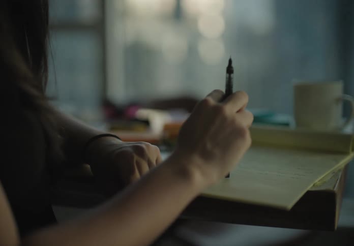 A woman with a pen writing on a pad